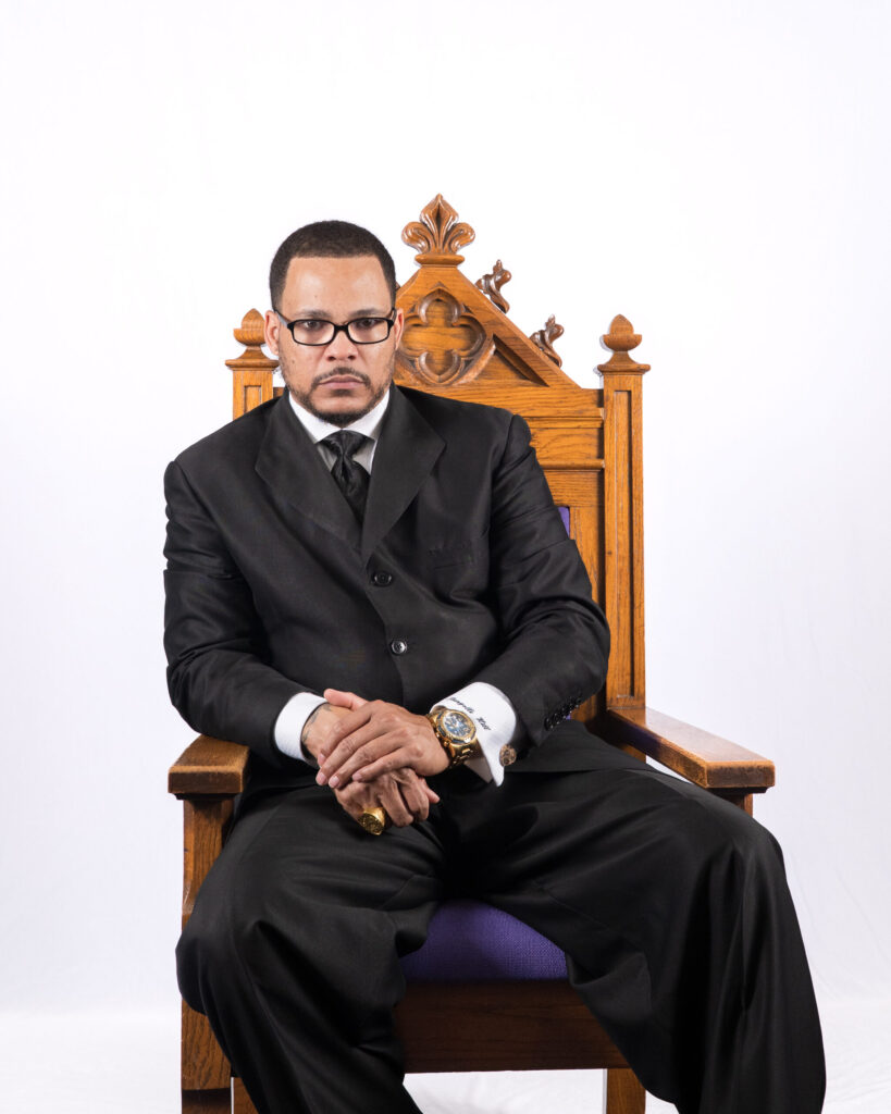 Bishop Tiangello T. Hill sitting in a chair